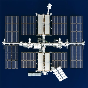 A Large Space Station With A Satellite Attached To The Side
